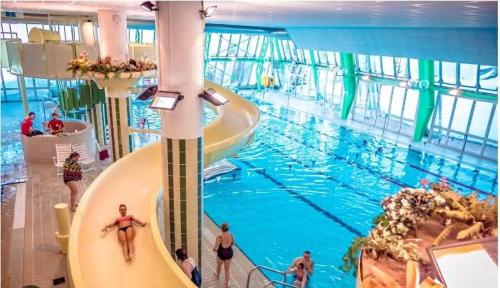 a large swimming pool with people walking around it at appartement au pied des pistes in Orcières