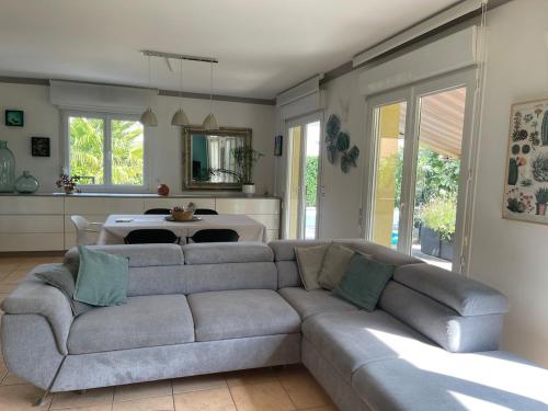 a living room with a gray couch and a table at Villa "La Tourelle" avec piscine privée in Haguenau