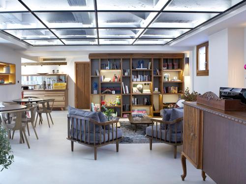 a living room with chairs and a table and a book shelf at Apollon Library Suites in Nafpaktos