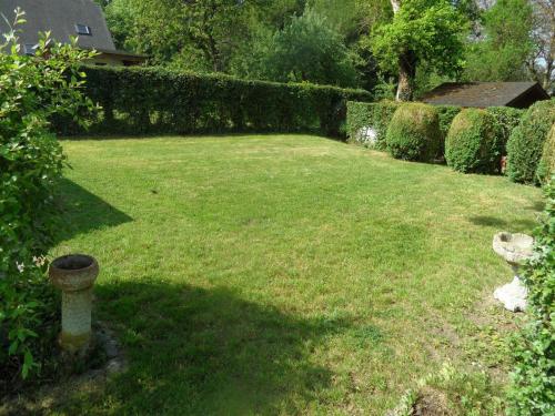 a yard with green grass and a hedge at Nice gite with low ceilings in Han-sur-Lesse in Han-sur-Lesse