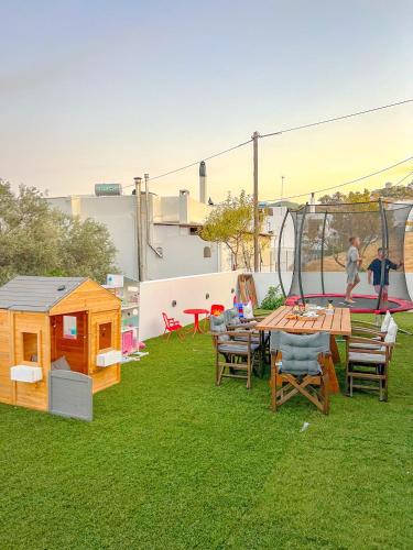 a backyard with a picnic table and a playground at Apademia Skyros Luxury Residences in Skiros