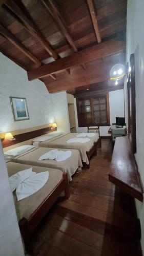 a row of beds in a room with wooden ceilings at Pousada dos Veleiros in Nova Almeida