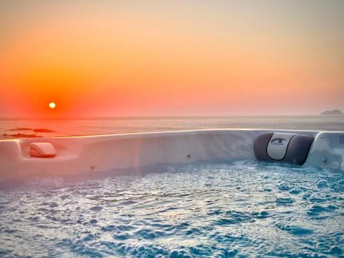 a bathtub filled with water with the sunset in the background at Falasarna's Dream in Kissamos
