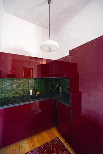 a red kitchen with a sink and red walls at Space Age Residence in Łódź