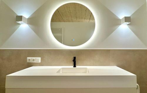a bathroom with a white sink and a mirror at See I Jacuzzi I Balkon I Parkplatz I Bio Hof I TV in Rieden am Forggensee