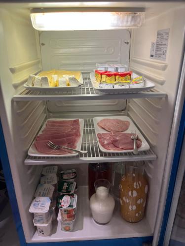 an open refrigerator with meat and other food items at Hotel Au Spatial in Amiens