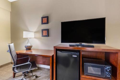 a room with a desk with a television and a chair at Comfort Inn Aikens Center in Martinsburg