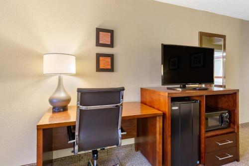 a room with a desk with a television and a chair at Comfort Inn Aikens Center in Martinsburg