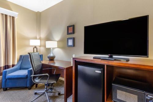 a hotel room with a flat screen tv and a chair at Comfort Inn Aikens Center in Martinsburg