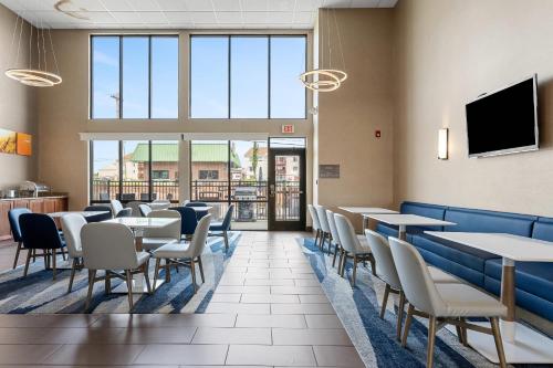 a dining room with tables and chairs and a flat screen tv at Comfort Inn Aikens Center in Martinsburg