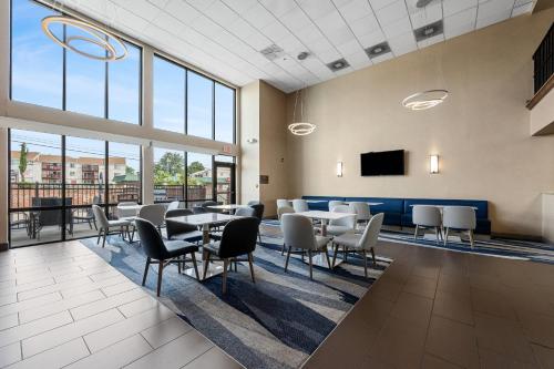 a dining room with tables and chairs and windows at Comfort Inn Aikens Center in Martinsburg