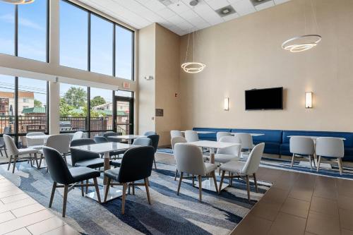 a waiting room with tables and chairs and a tv at Comfort Inn Aikens Center in Martinsburg
