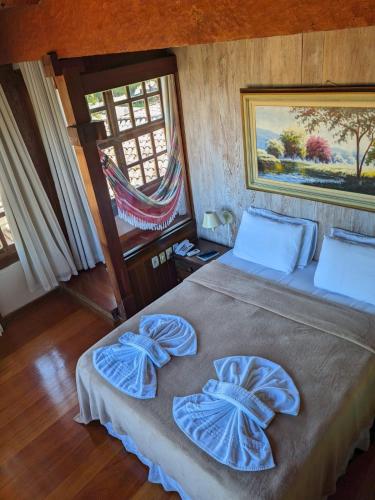 a bedroom with a bed with blue sheets and a window at Pousada dos Veleiros in Nova Almeida