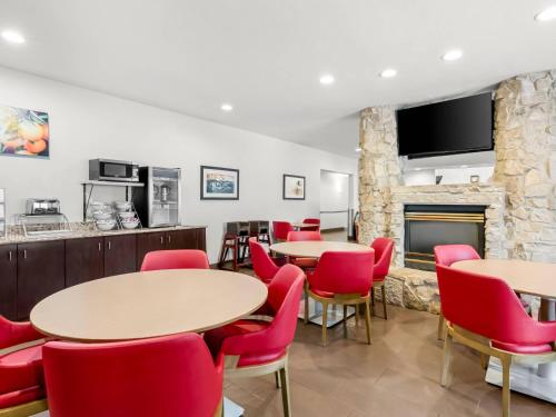 a room with tables and chairs and a fireplace at Comfort Inn & Suites Bellevue - Omaha Offutt AFB in Bellevue