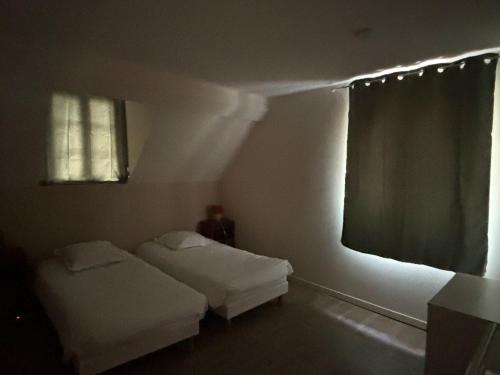 a small room with two beds and a window at Le Manoir de Conteville in Paluel