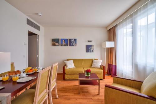 a living room with a couch and a table at Clarion Paris CDG Airport in Roissy-en-France