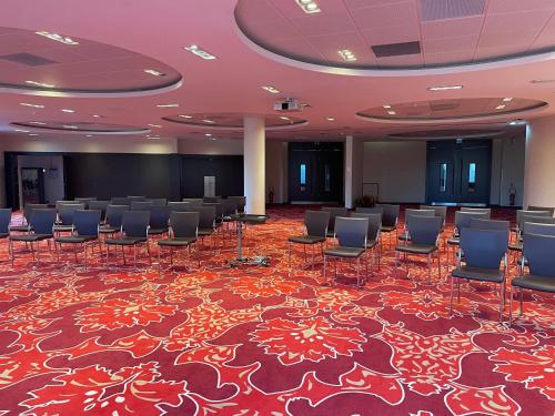 a conference room with chairs and a stage in it at Clarion Paris CDG Airport in Roissy-en-France