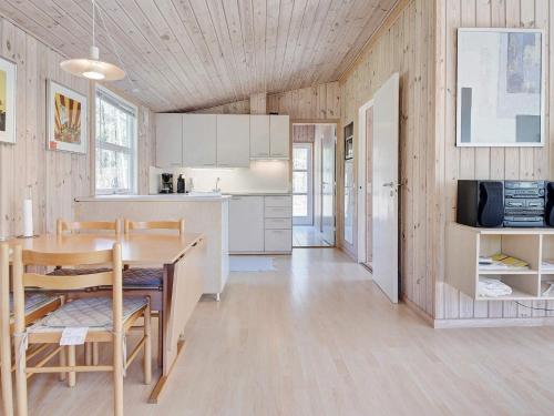 a kitchen and dining room with a table and chairs at 4 person holiday home in Nexø in Neksø
