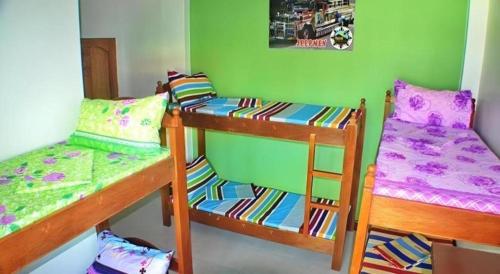 a room with two bunk beds and a chair at Mayon Backpackers Hostel in Legazpi