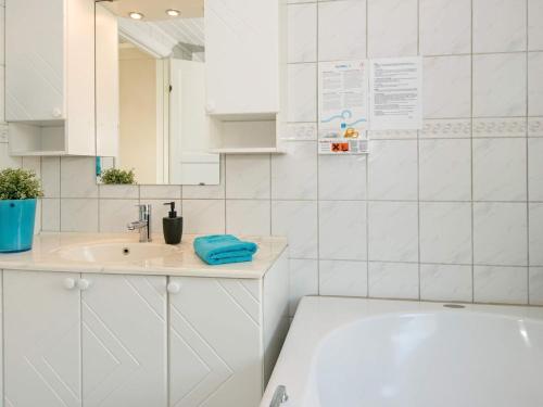 a white bathroom with a tub and a sink at 6 person holiday home in Hejls in Hejls