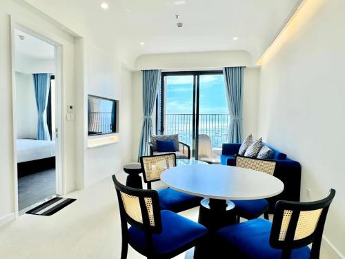 a living room with a table and chairs and a bedroom at Sunset town Phú Quốc in Phu Quoc