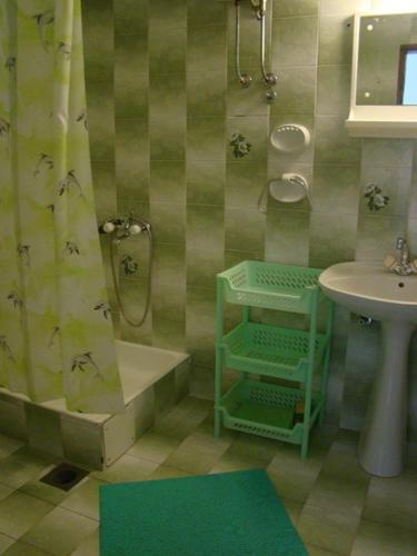 a bathroom with a sink and a shower with a shower curtain at Apartments Svorcan in Budva