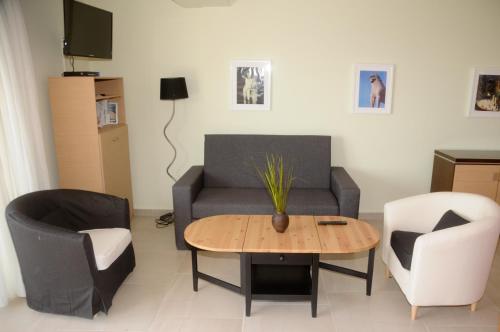 a living room with a couch and a table and chairs at Aegean View Villa in Loutraki