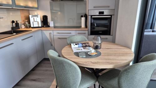 a small kitchen with a wooden table and chairs at Ferienwohnung Villa Grimm in Burbach