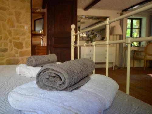 eine Gruppe Handtücher auf dem Bett in der Unterkunft Le Coustal in Auriac-du-Périgord