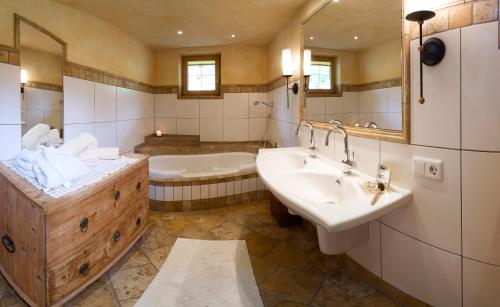 y baño con bañera, 2 lavabos y bañera. en Alpen-Chalet-Pankraz, en Fügenberg