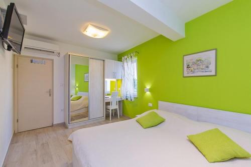 a bedroom with a white bed and green walls at Villa Porto in Mlini