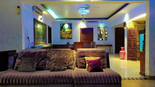 a living room with a couch with pillows on it at Luxury Furnished Apartment in Dhaka