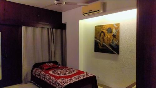 a bedroom with a bed and a painting on the wall at Luxury Furnished Apartment in Dhaka