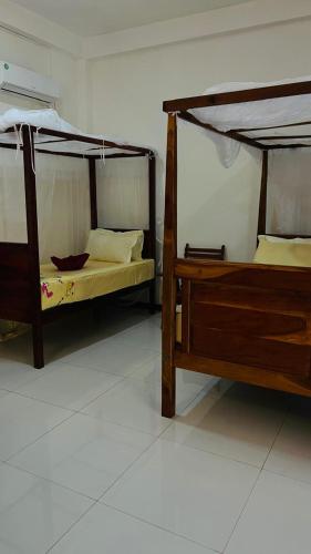 two bunk beds in a room with a white floor at Mahee house in Hiriketiya