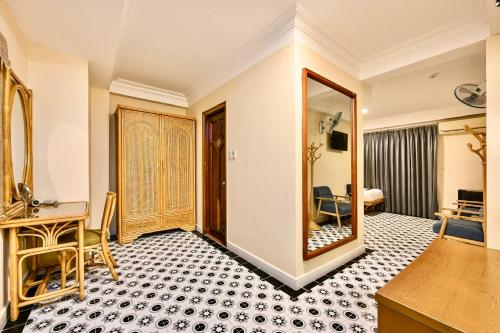 une chambre d'hôtel avec un bureau et un miroir dans l'établissement Spring House Saigon central park, à Hô-Chi-Minh-Ville