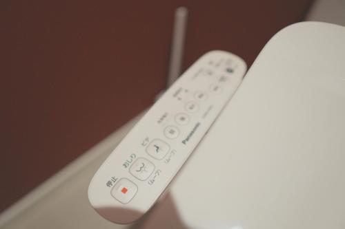 a white remote control sitting on top of a table at Ocean Front! Simple Resort YAKA in Kin
