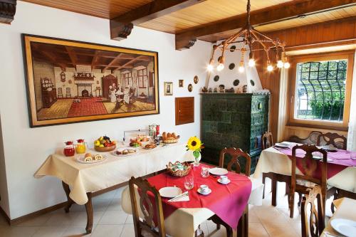 佩利札諾的住宿－B&B Cà dei Baroni，一间设有两张桌子的用餐室和墙上的绘画