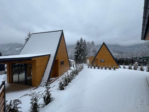 a couple of small wooden buildings in the snow at A-Frame Valley in Buşteni