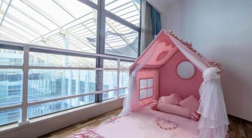 a bedroom with a pink bed with a dress on it at Beluga Sanya Discovery Ocean World in Shangsimacun