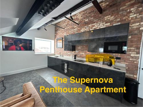a kitchen with a counter and a brick wall at Swish Luxury Holiday Apartments in Blackpool