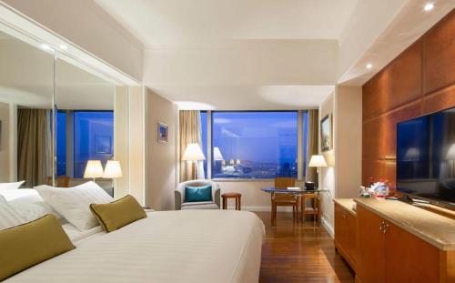 a hotel room with a large bed and a large window at Kai Wah Plaza International Hotel in Kunming