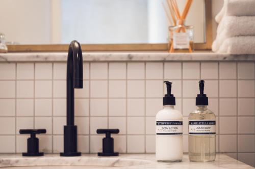 two bottles of soap on a counter next to a sink at Morgan & Mees Amsterdam in Amsterdam