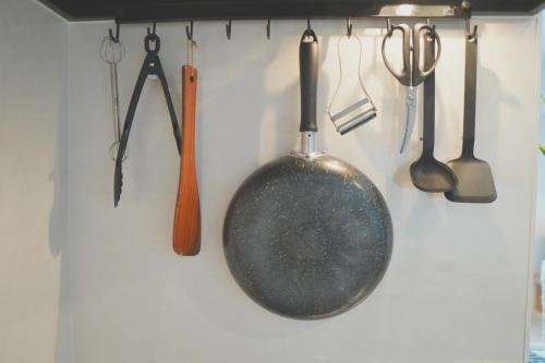 a pan and other kitchen utensils hanging on a wall at Ocean Front! Simple Resort YAKA in Kin
