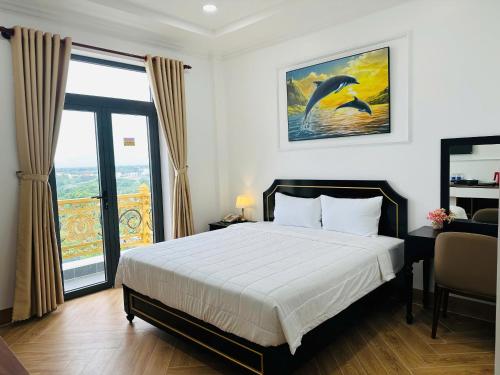 a bedroom with a bed and a large window at khách sạn yên châu 2 in Chau Doc