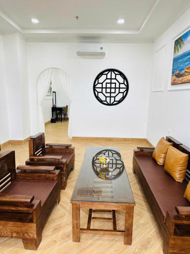 a living room with couches and a table in a room at khách sạn yên châu 2 in Chau Doc