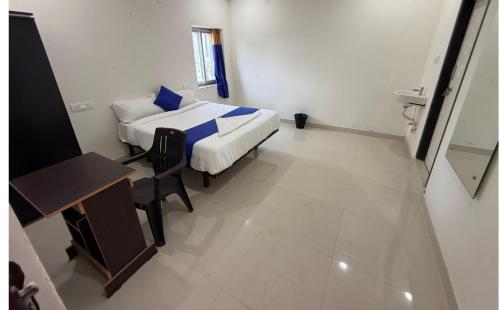 a small room with a bed and a desk and a chair at COCO NET Hotel in Ibrāhīmpatan