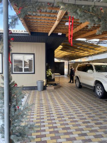 a white suv parked in a garage with red bows at Apart 23 in Karakol