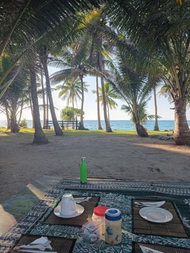a table with plates of food on the beach at Nenas Homestay in Soso