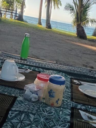 a picnic table with food and a drink on the beach at Nenas Homestay in Soso