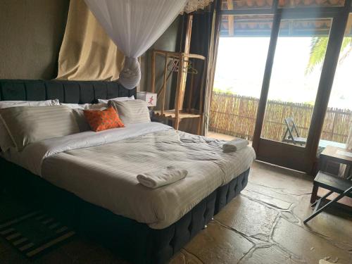 a bedroom with a large bed with a window at Palm garden Resort in Gisenyi